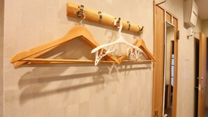 Un pasillo con percheros de madera y una puerta.
