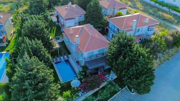 Une vue aérienne d’un quartier résidentiel avec de nombreuses maisons, une piscine et une végétation luxuriante.
