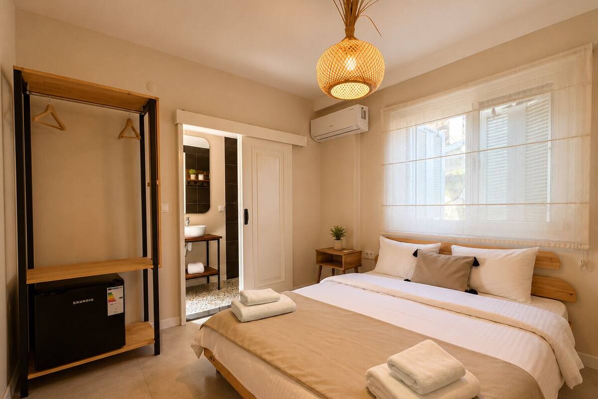 A bedroom with a bed, bedside tables, a wardrobe, a mirror, and a window.