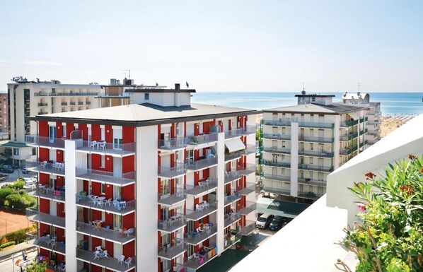 A multi-story hotel with balconies, a beach view, and a parking area.