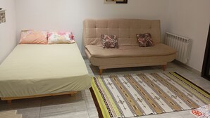 A room with a bed, a sofa, a patterned rug, and a wall-mounted picture. - VIP Tunisia  (Halq al Wadi)
