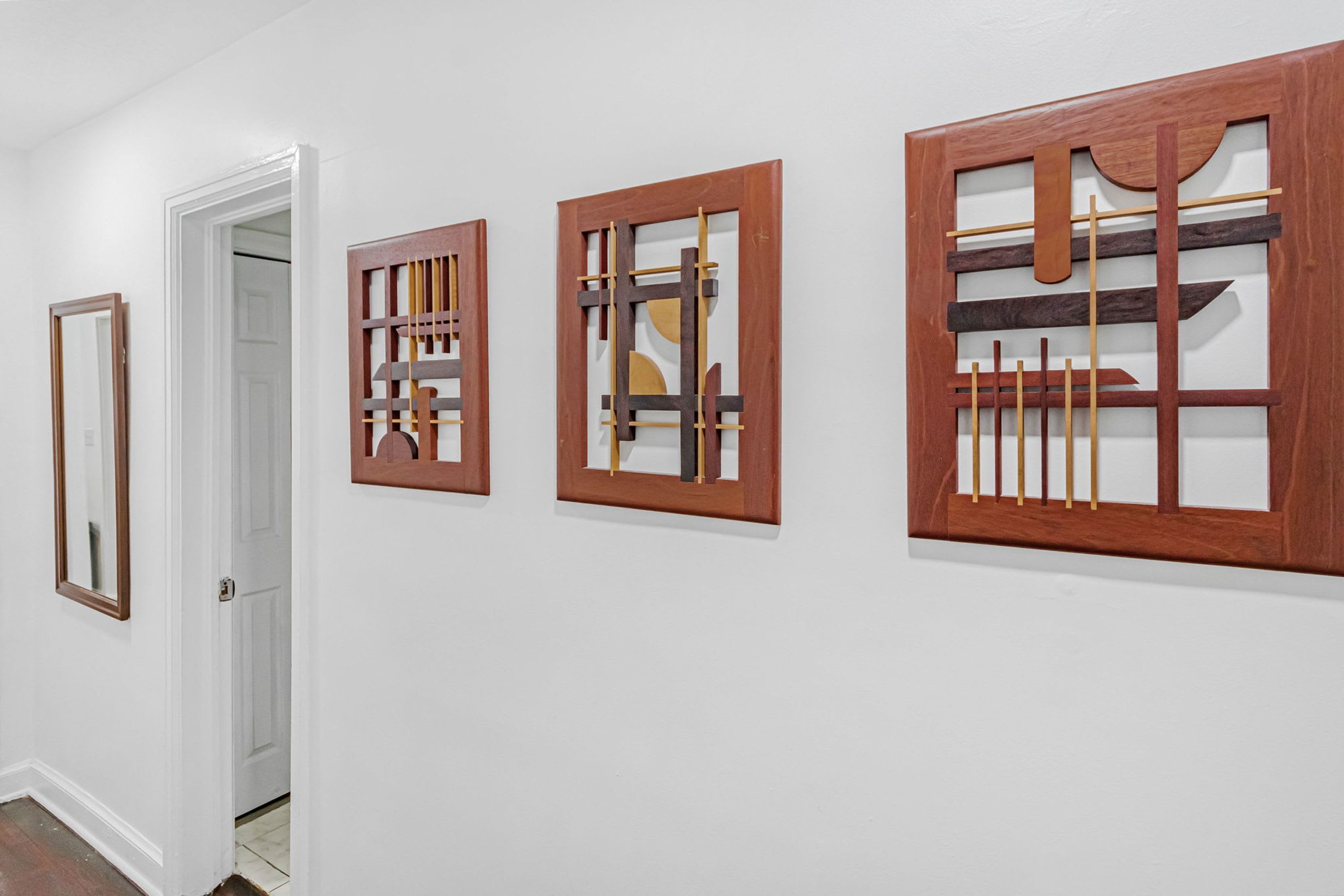 Um corredor com três obras de arte emolduradas na parede.