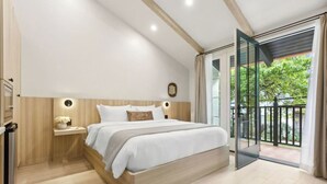 Une chambre moderne avec un grand lit, une table de chevet avec une lampe et une vue sur un balcon.