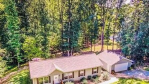 A two-story house with a front porch, a garage, and a well-maintained lawn. - Waterfront LKN Hideaway Relax & Recharge (Troutman)