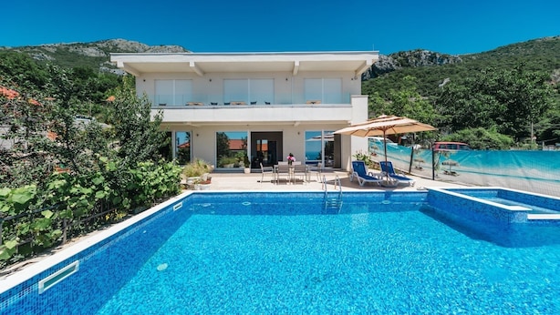 Una casa moderna de dos pisos con piscina delantera.