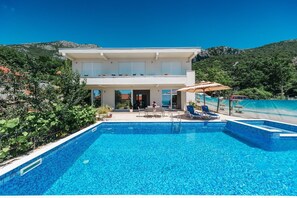 Ein modernes, zweistöckiges Haus mit Pool.
