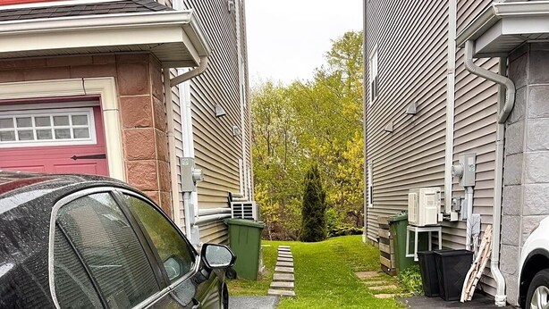 En svart bil stod parkerad på en uppfart bredvid ett hus med en röd garageport.