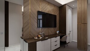 Una cocina moderna con protector de salpicadero de madera, televisor empotrado y encimera con frutero y hervidor.