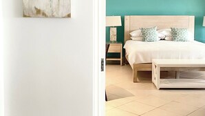 A bedroom with a bed, bedside tables, and a painting on the wall.