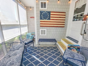 A patio area with a flag mural, outdoor seating, and a view of the street.