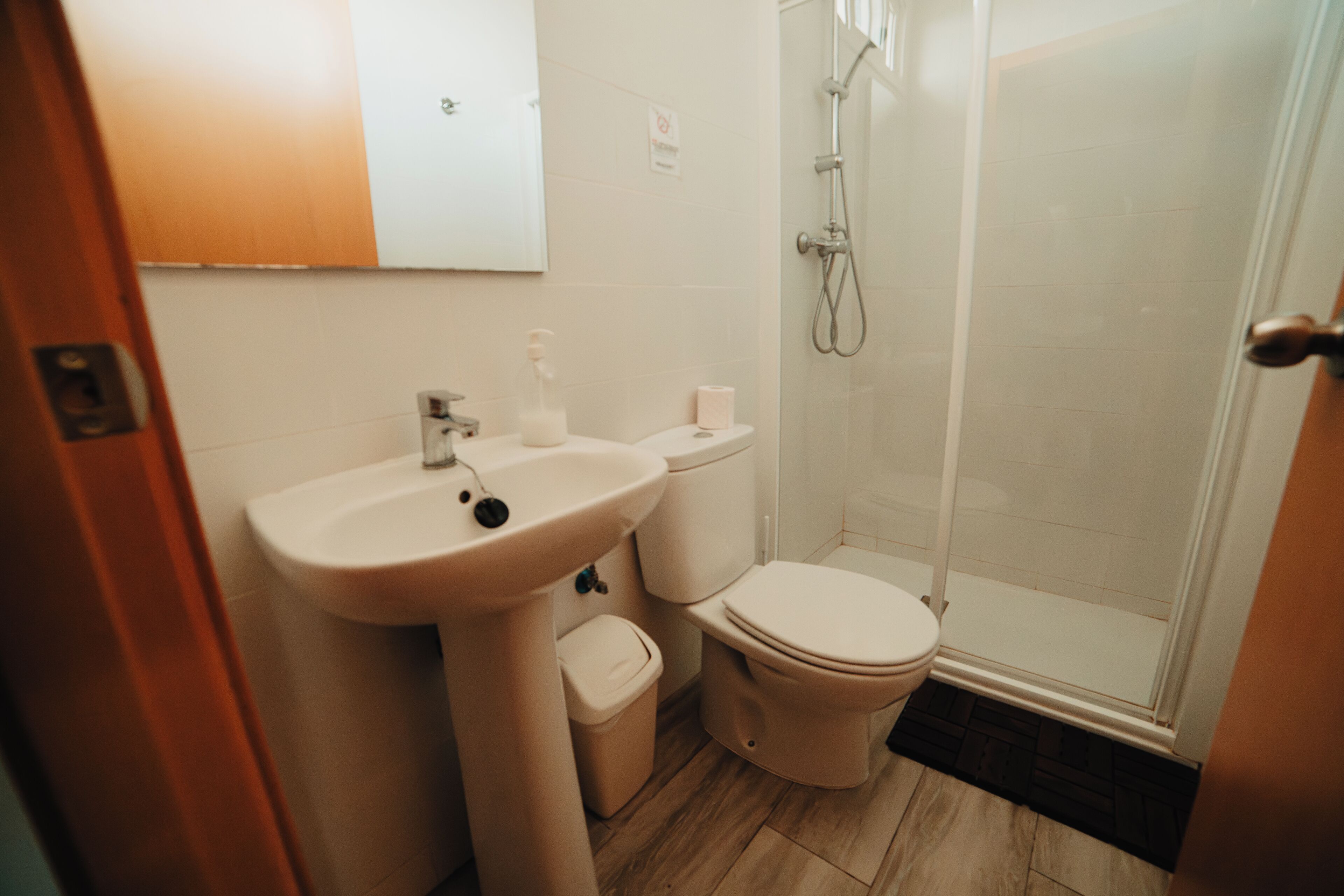 Un baño con lavamanos, inodoro y ducha.