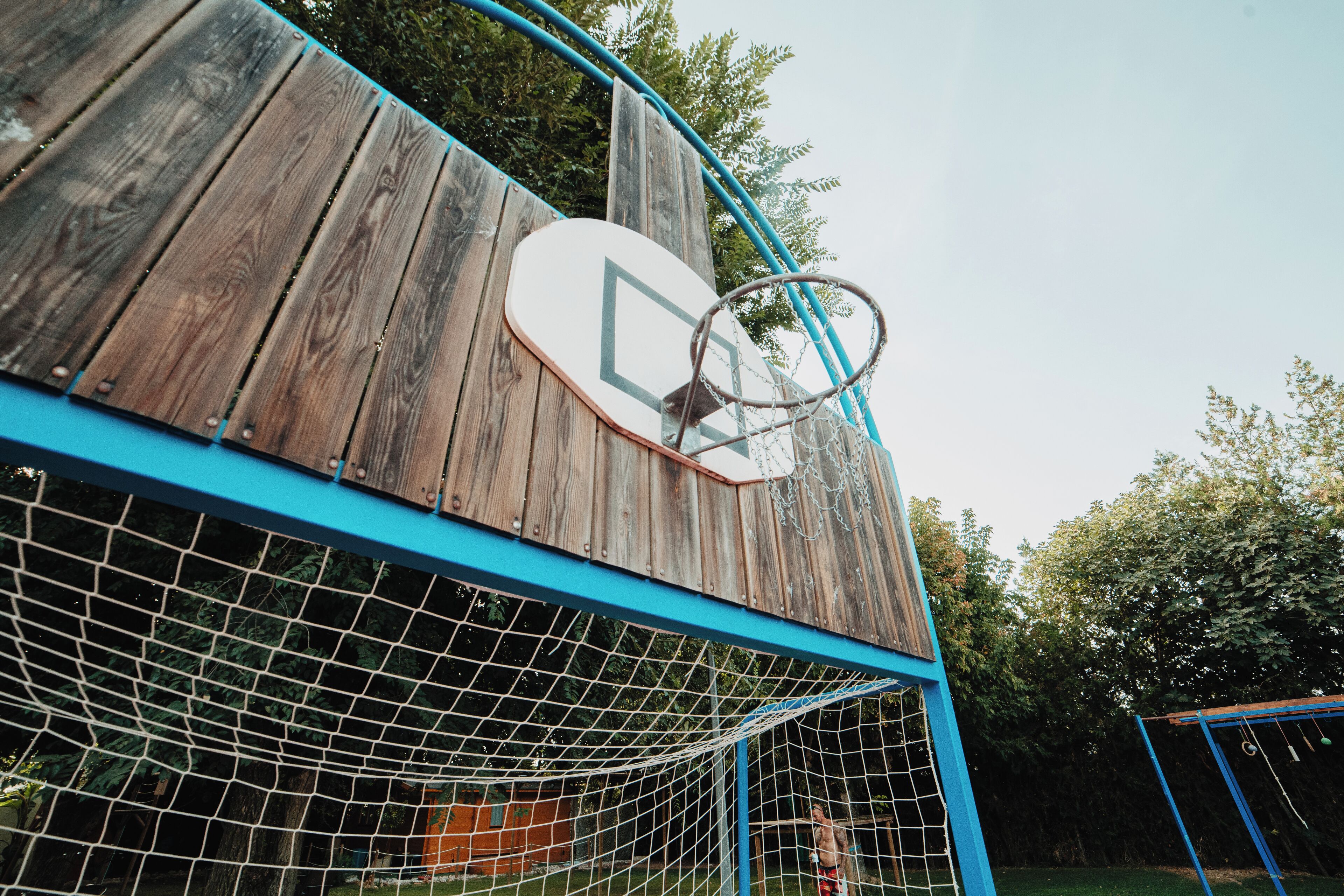 Un aro de baloncesto adosado a una estructura de madera con marco azul.