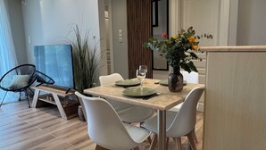 Un espace repas moderne avec une table en bois, des chaises blanches et un vase rempli de fleurs.