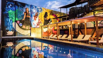 Alberca al aire libre, sombrillas en la alberca y camastros