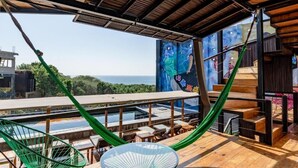 A hammock on a wooden deck with a view of the ocean. - Cabane Container Hotel - Adults Only (Puerto Escondido)