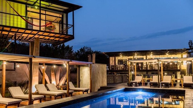 A modern hotel with a pool, lounge chairs, and a bar area. - Cabane Container Hotel - Adults Only (Puerto Escondido)