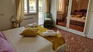 A bedroom with a bed, a chair, and a view of another room through a sliding door. - Vacation House Fiore Ciampino Airport - Rome Station (Ciampino)