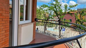 A balcony with a metal railing, a brick wall, and a window. - Vacation House Fiore Ciampino Airport - Rome Station (Ciampino)