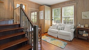 Ein Holzinterieur mit einer Treppe, einem weißen Sofa und einem Holzboden.