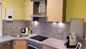 Een moderne keuken met een inbouwoven, een magnetron en een koffieapparaat.