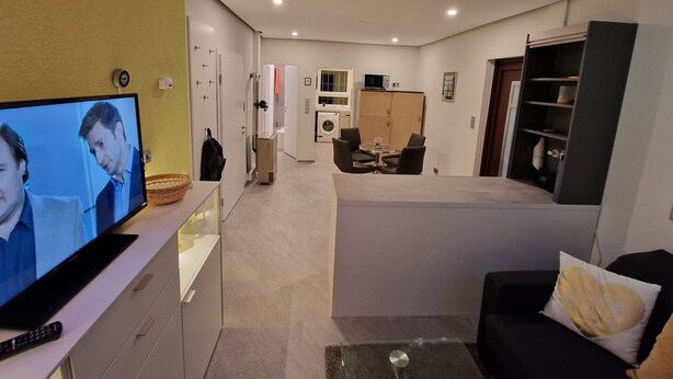 Een moderne woonkamer met een flatscreen televisie, een bank en een salontafel.