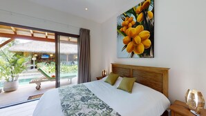 Un cuarto de hotel con una cama, un ventanal grande, un cuadro de flores amarillas y vistas a una zona de piscina.