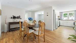 A modern kitchen with white cabinets, a stainless steel refrigerator, and a window with a view of greenery. - Luxury King Suite, 125-yr historic home, 2 blocks from Main St. Crib included (Clayton)