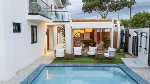 Een modern huis met een zwembad, terras en een verzorgde tuin.