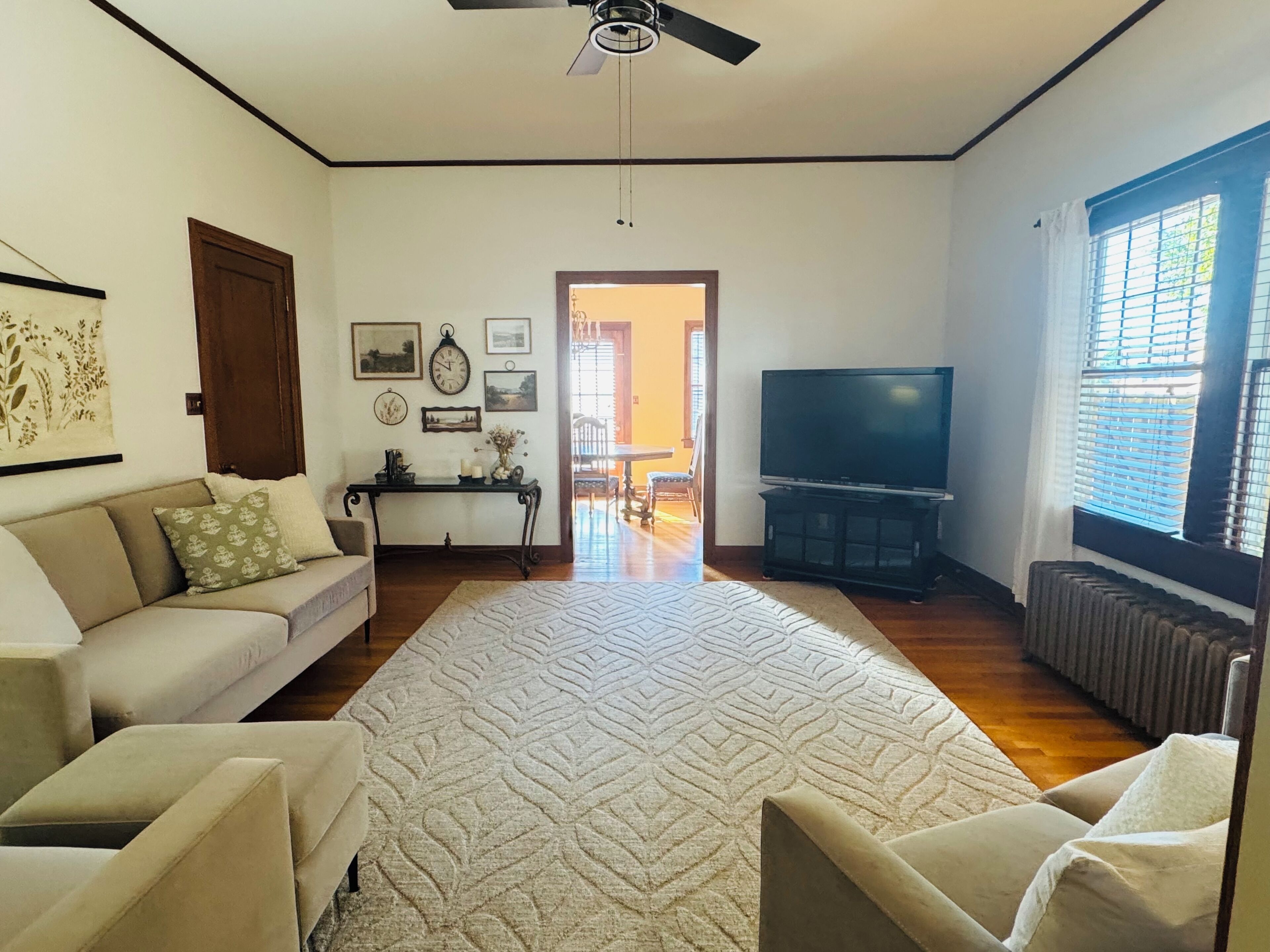 Un salon comprenant un canapé, un téléviseur, une table basse et un tapis à motifs.