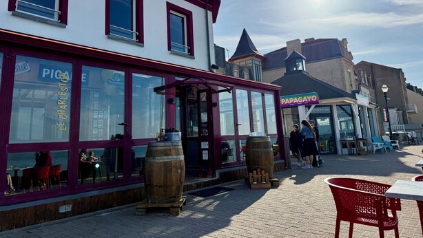 A waterfront building with large windows and a wooden barrel outside. - "La Victoire" Fisherman's house at an alleyway from the sea... (Saint-Aubin-sur-Mer)