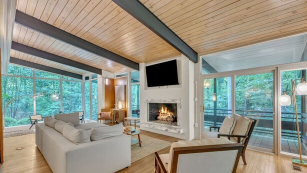A modern living room with a fireplace, large windows, and a cozy seating area.