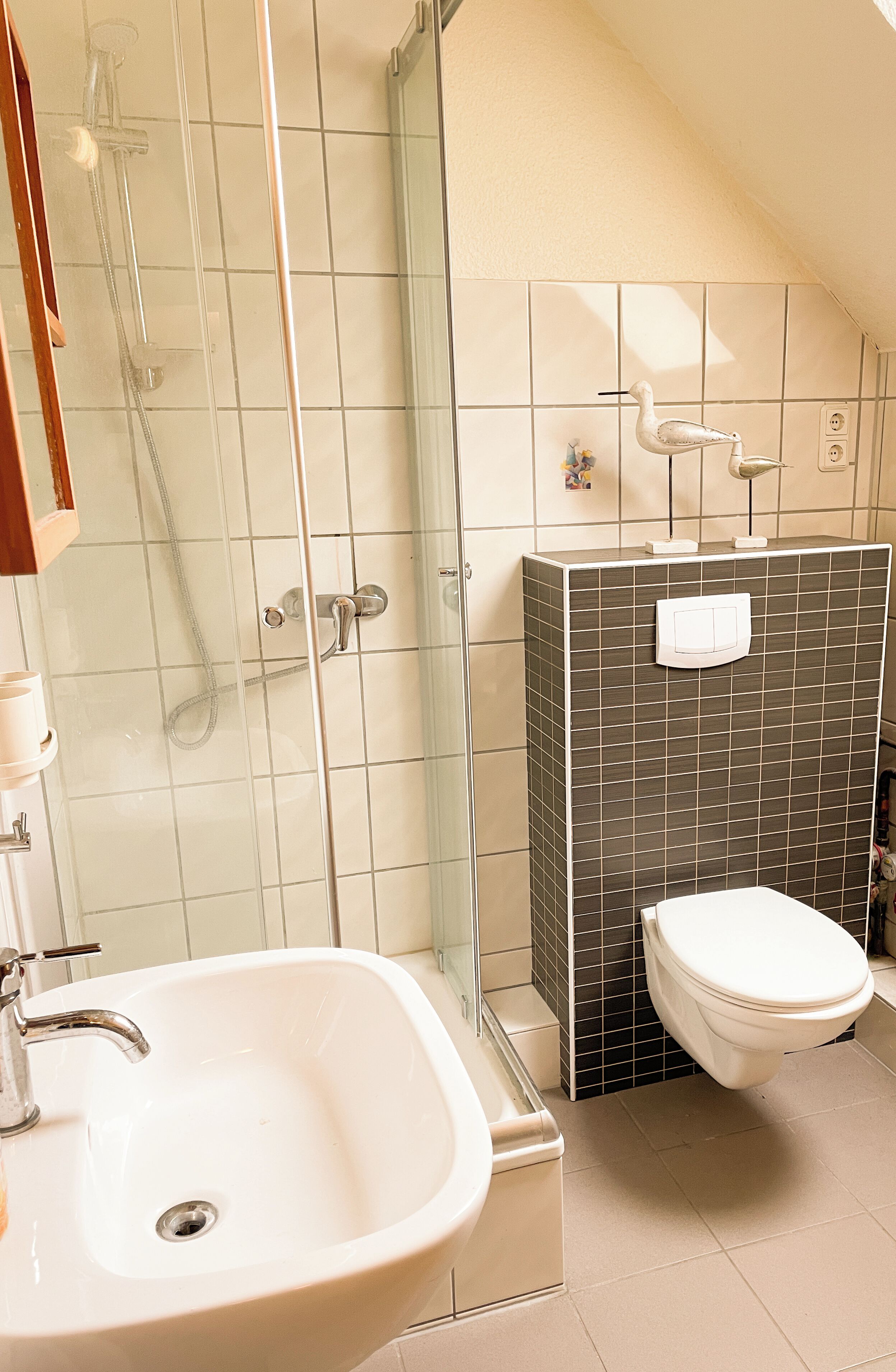 Une salle de bain avec une douche à parois de verre, un lavabo blanc et des toilettes.