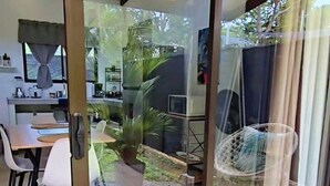 Eine moderne Küche mit Essbereich, einer Schiebeglasdoor zum Garten und einer Topfpflanze.