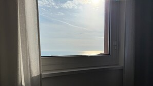 Une fenêtre donnant sur le ciel et un paysage lointain.