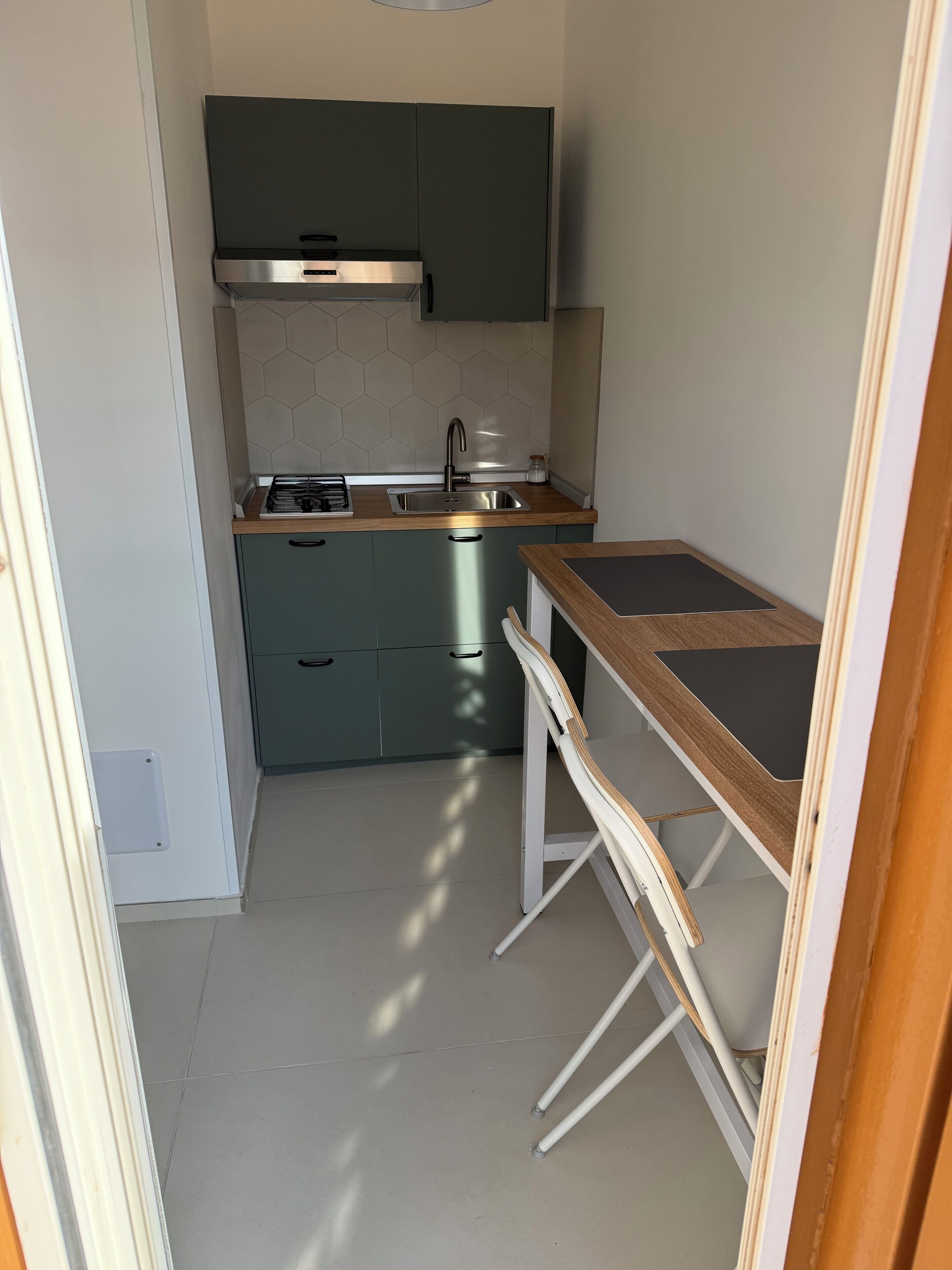 A compact kitchen with a stainless steel sink, a built-in stove, and a small countertop.