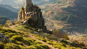 Un castillo en una colina con vistas del paisaje circundante.