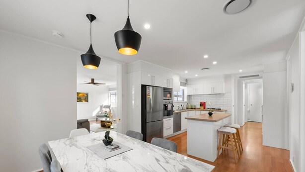 A modern kitchen with white cabinetry, a central island, and a dining area with a marble table. - Family house,3 Rooms,4Beds, 5 to 8 People,Pet-Friendly Big Yard lots of Parking (Duffy)