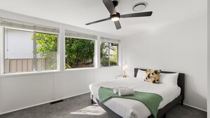 A bedroom with a bed, a ceiling fan, and large windows. - Family house,3 Rooms,4Beds, 5 to 8 People,Pet-Friendly Big Yard lots of Parking (Duffy)
