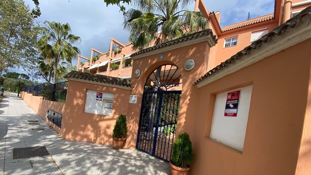 A gated entrance with a tiled pathway leading to a building with a tiled roof and a small balcony. - Cozy apartment with private garden in Marbella (Marbella)