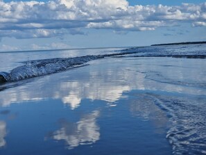 A beach with wet sand and gentle waves. - 6 Person Holiday Home in Hadsund (Hadsund)