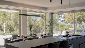 Una cocina moderna con una isla grande, taburetes de bar y vistas al exterior.