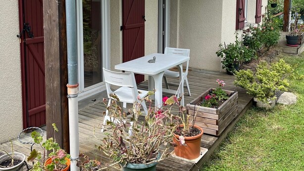 A rustic house with a wooden deck, a white table and chairs, and potted plants. - Quiet and surrounded by nature 10 mm from the A75 freeway (Montcel)