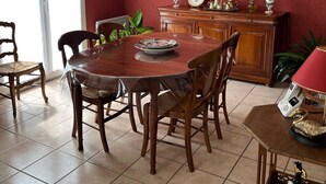 A dining area with a round wooden table, chairs, a chandelier, a cabinet with decorative items, and a painting on the wall. - Quiet and surrounded by nature 10 mm from the A75 freeway (Montcel)