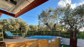 A swimming pool with a wooden deck, surrounded by artificial grass and pebbles. - QUIET ESCAPE (CHORA MESSINIAS)