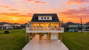 Uma casa à beira-mar com varanda, garagem e gramado.