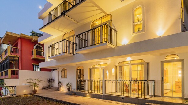 A multi-story hotel with balconies, large windows, and a well-lit entrance. - Hotel Green Park (New Delhi)