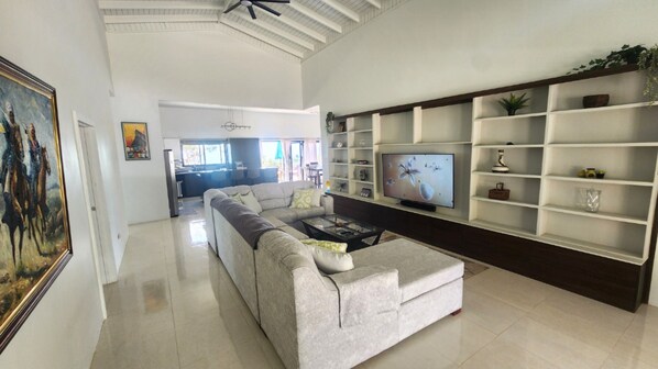 Relax in this spacious living area with a large sofa, flat-screen TV, and dining space.