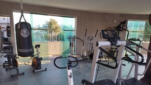 A gym with cardio machines, weightlifting equipment, and a punching bag. - Corporate Accommodation (Parque das Universidades Campinas)