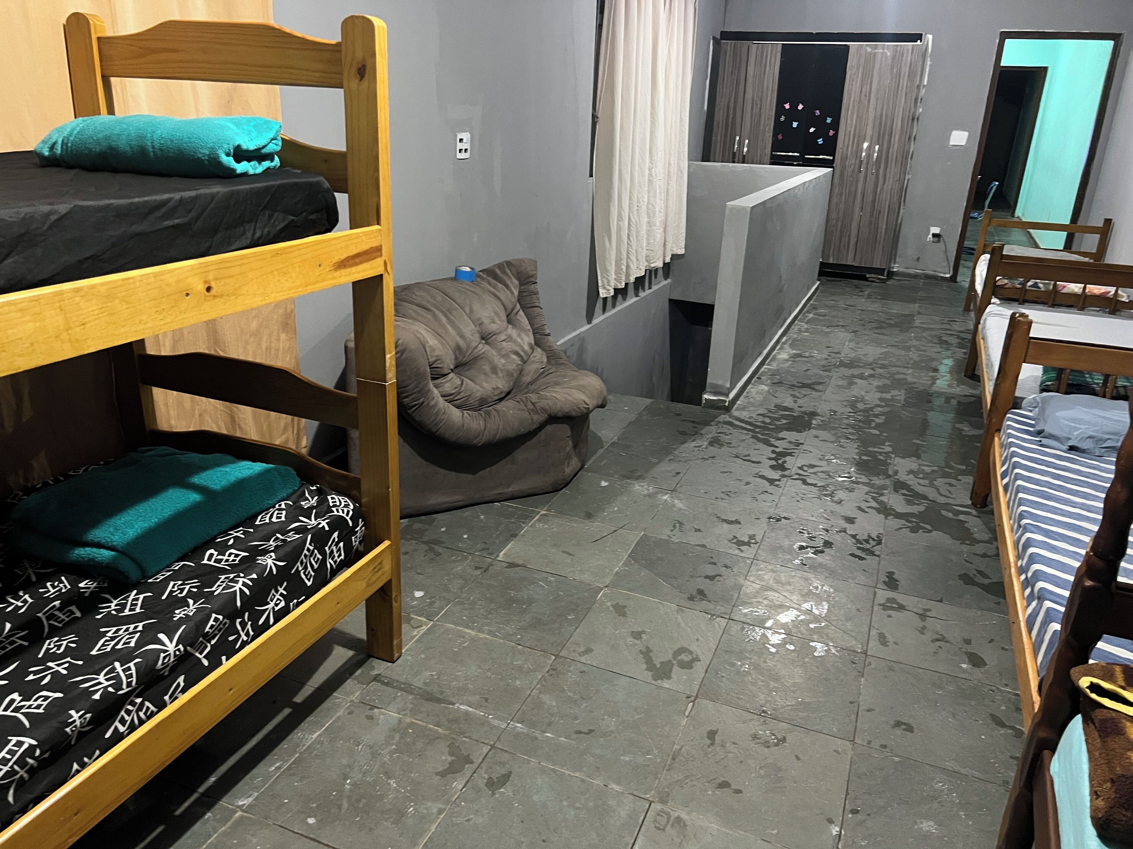 A dormitory room with bunk beds, a bean bag chair, and a small desk.