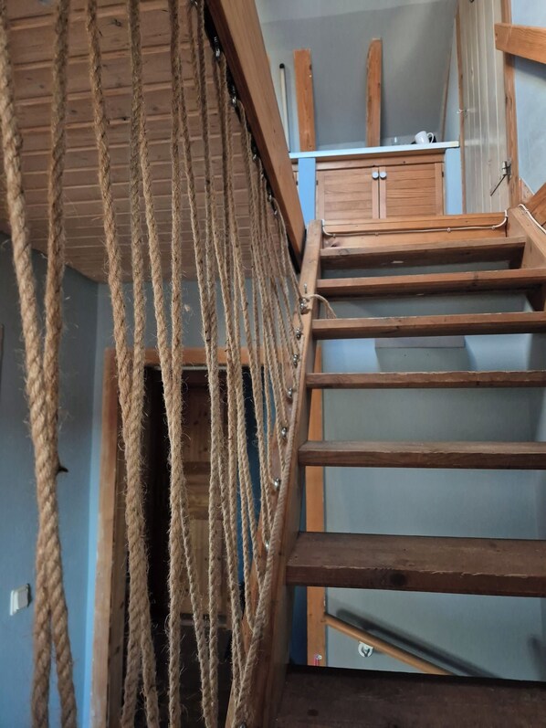 A wooden staircase with a rope barrier.